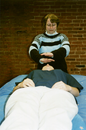 Linda practices Reiki on student